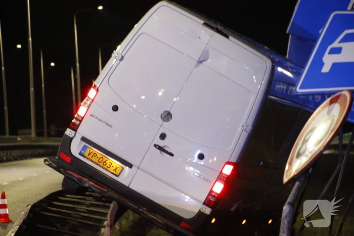 Bestelbus rijdt op vangrail en raakt verkeersborden