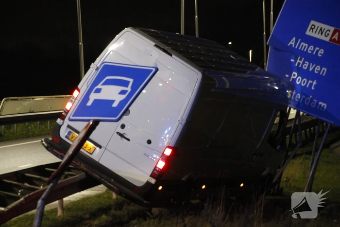 Bestelbus rijdt op vangrail en raakt verkeersborden