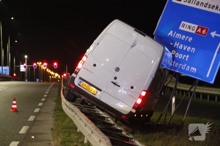 Bestelbus rijdt op vangrail en raakt verkeersborden