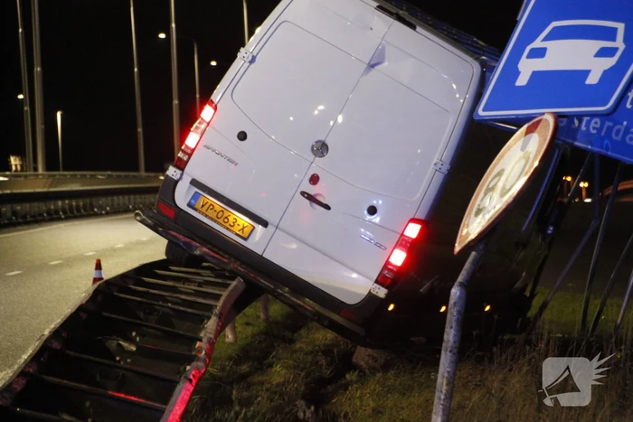 Bestelbus rijdt op vangrail en raakt verkeersborden