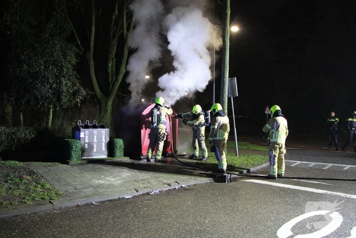 Brandweer blust brandende plasticcontainer