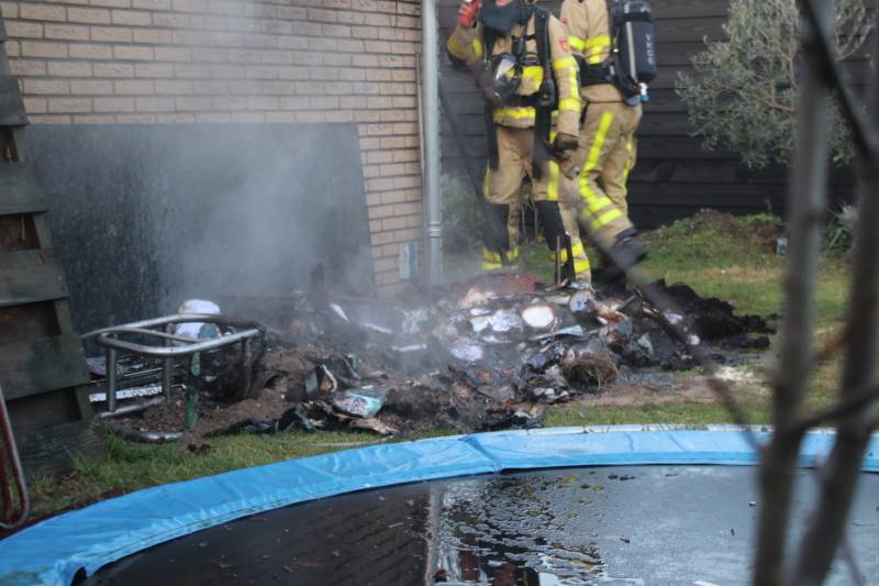 Brandweer blust afvalcontainer in tuin