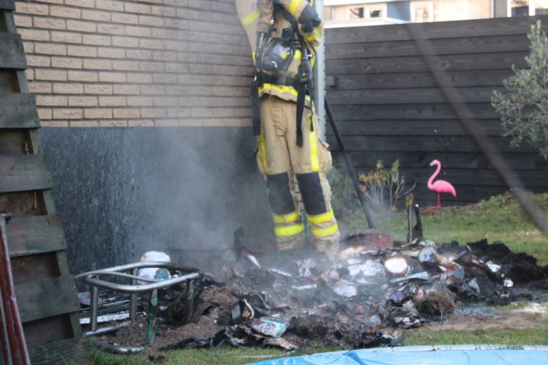 Brandweer blust afvalcontainer in tuin