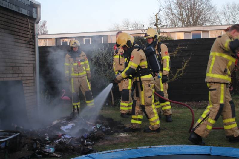 Brandweer blust afvalcontainer in tuin