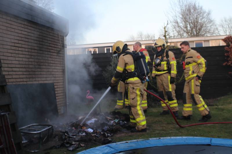 Brandweer blust afvalcontainer in tuin