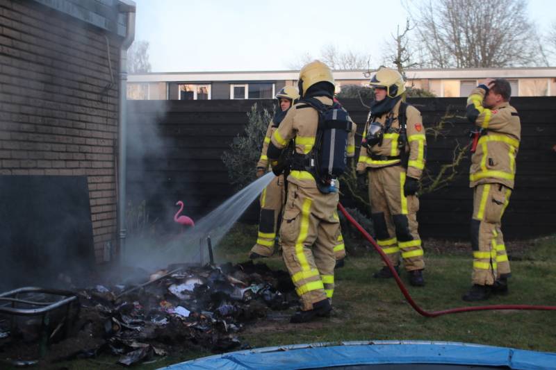 Brandweer blust afvalcontainer in tuin