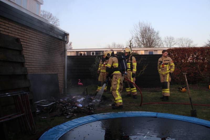 Brandweer blust afvalcontainer in tuin