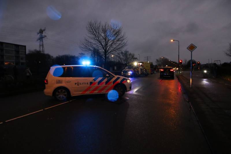 Personenauto schept wielrenner