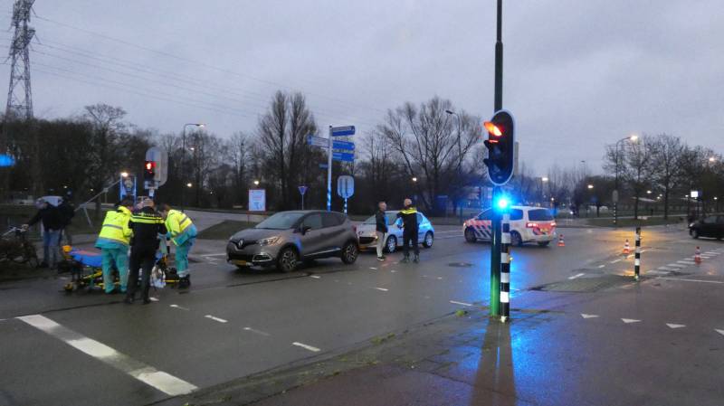 Personenauto schept wielrenner