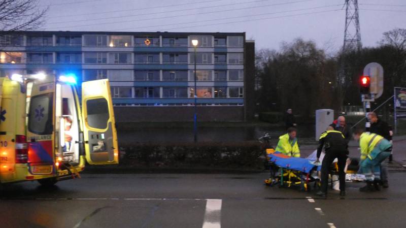 Personenauto schept wielrenner