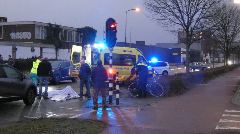 Personenauto schept wielrenner