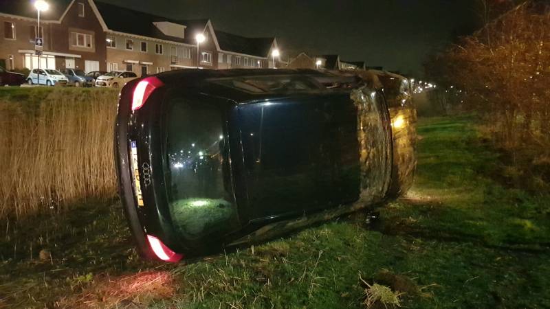 Automobilist verliest macht over het stuur en belandt met auto op de zijkant
