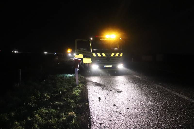 Auto vliegt uit de bocht op afrit en belandt in weiland