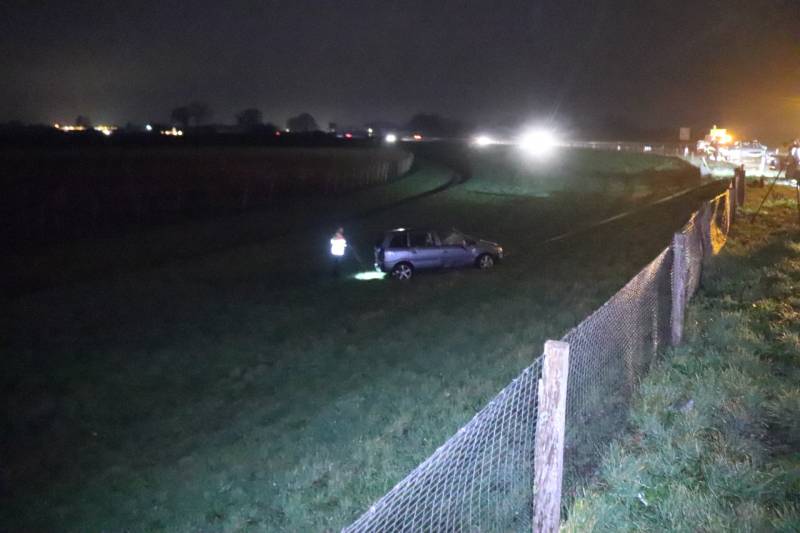 Auto vliegt uit de bocht op afrit en belandt in weiland