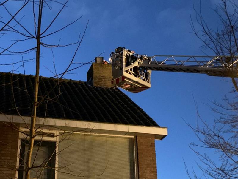 Brandweer controleert schoorsteenbrand met hoogwerker