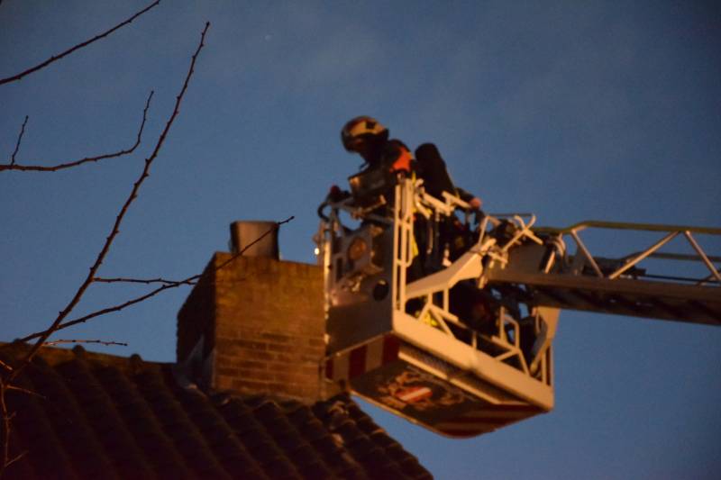 Brandweer controleert schoorsteenbrand met hoogwerker