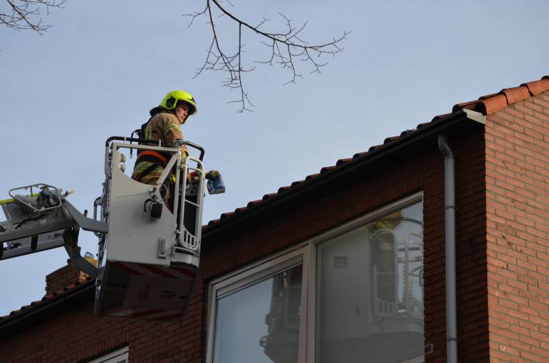 Brandweer redt kat uit dakgoot
