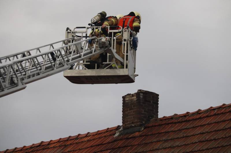 Brandweer veegt schoorsteen na brand