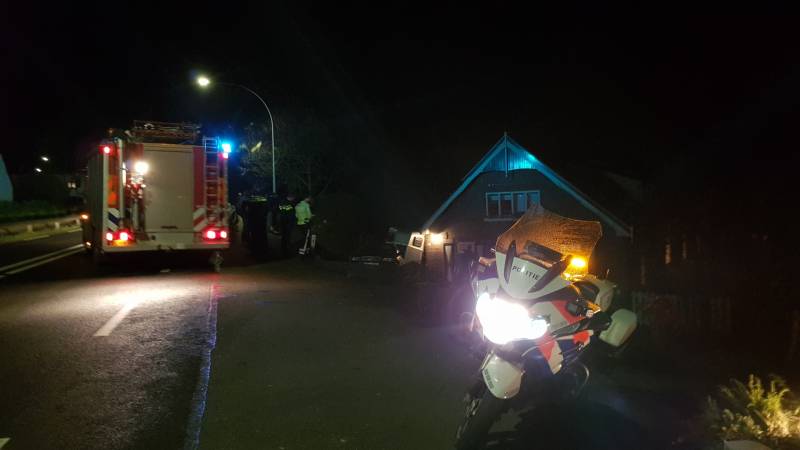 Auto met paardentrailer botst tegen huis.