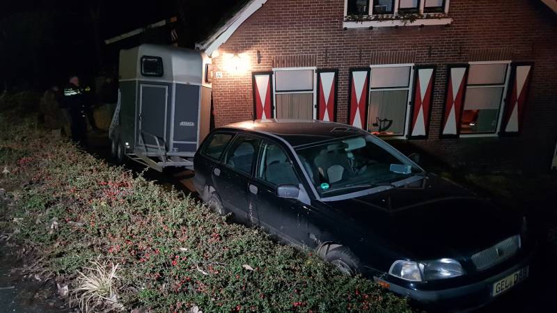 Auto met paardentrailer botst tegen huis.