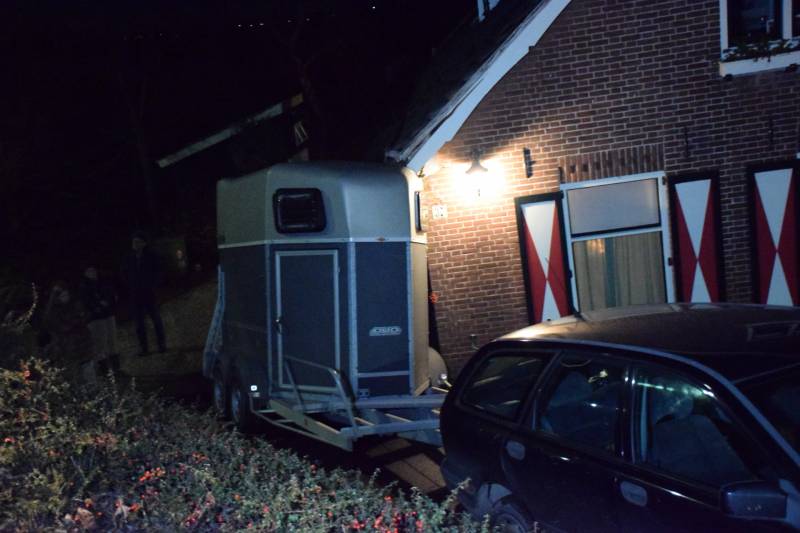 Auto met paardentrailer botst tegen huis.