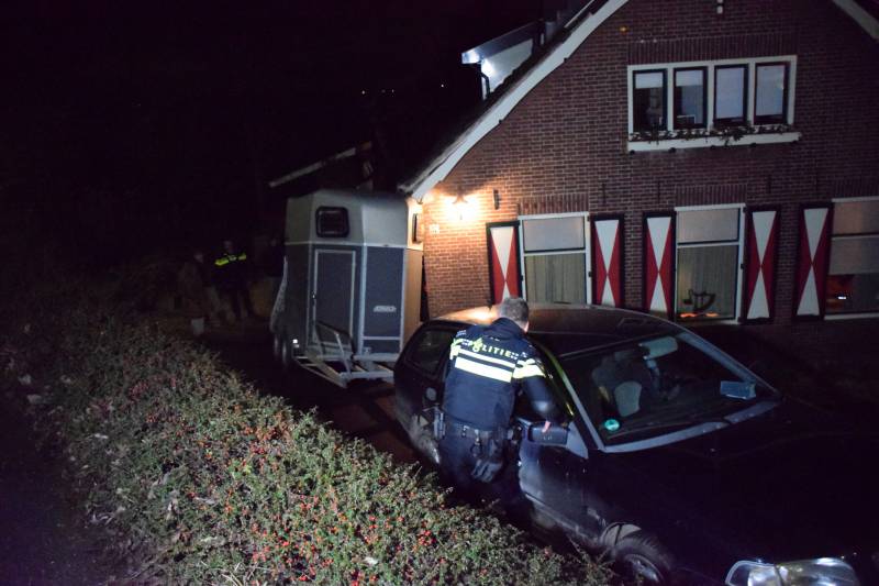 Auto met paardentrailer botst tegen huis.