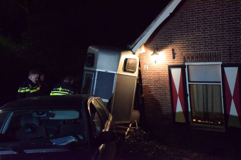 Auto met paardentrailer botst tegen huis.
