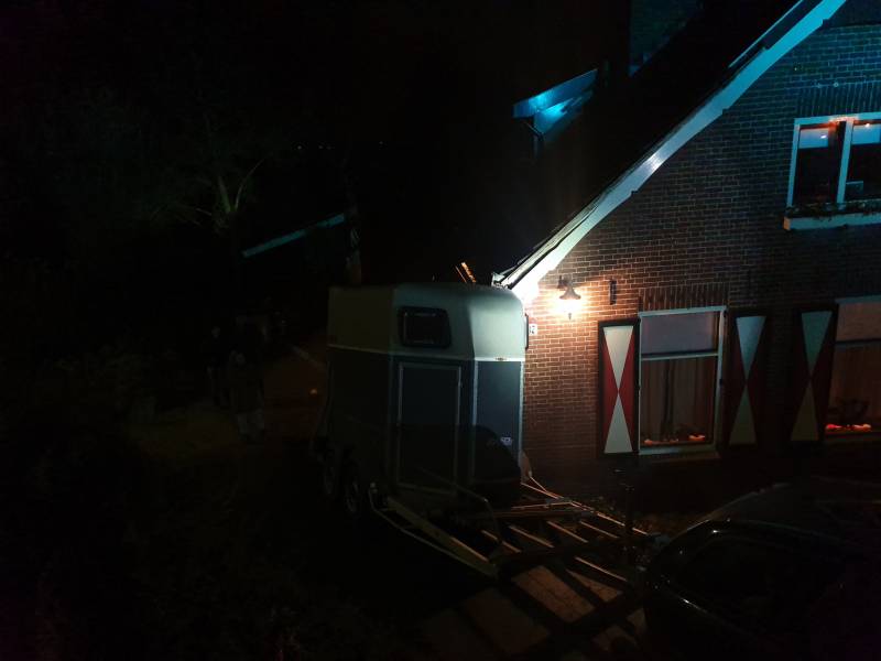 Auto met paardentrailer botst tegen huis.
