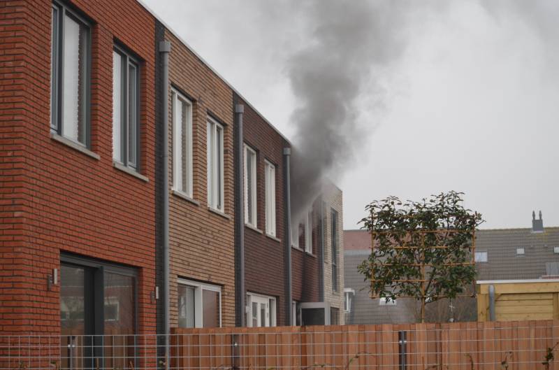 Dikke rookpluimen bij brand in woning