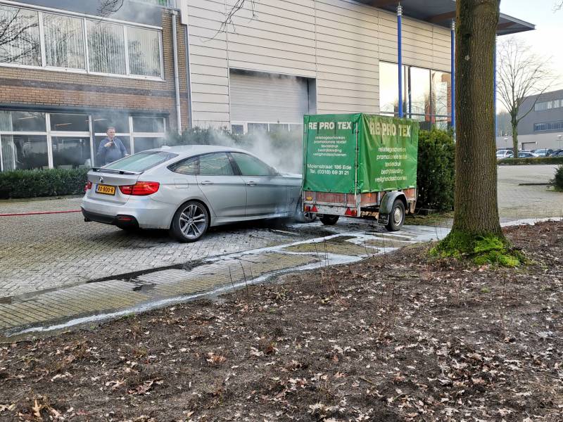 Medewerkers blussen beginnende autobrand