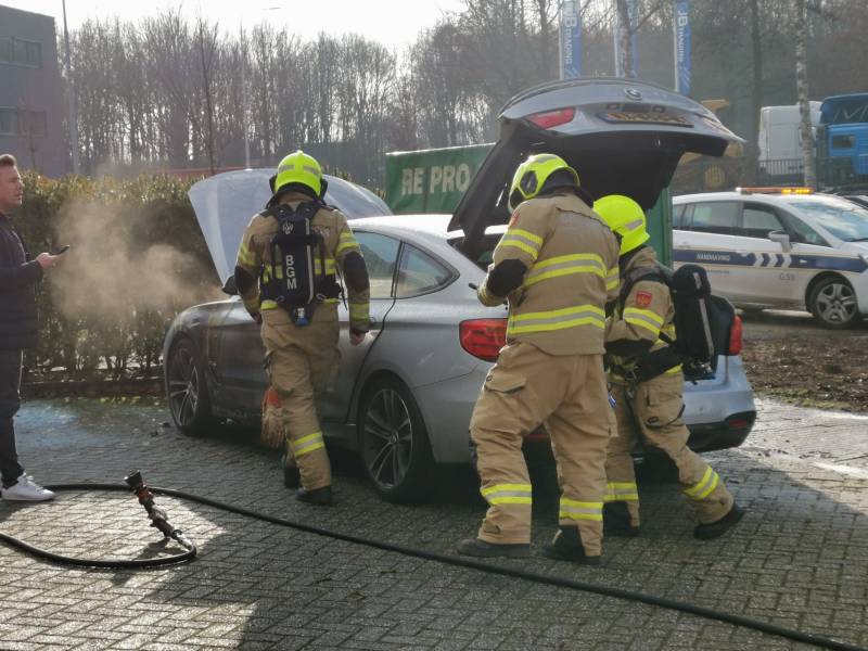 Medewerkers blussen beginnende autobrand
