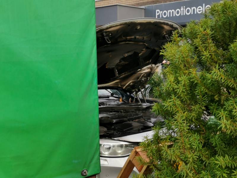 Medewerkers blussen beginnende autobrand