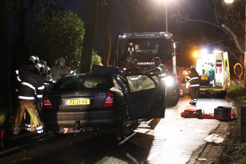 Bestuurder bekneld na botsing op boom