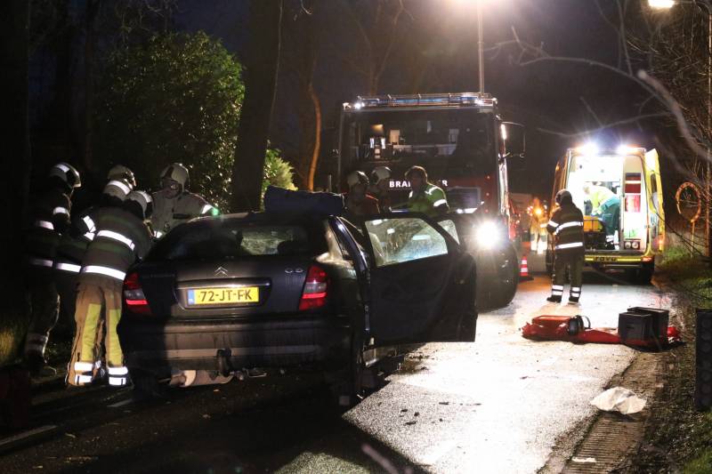 Bestuurder bekneld na botsing op boom
