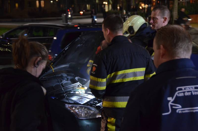 Brandweer inspecteert auto na brand