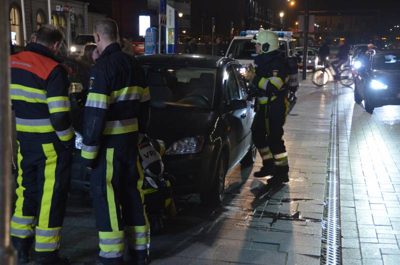 Brandweer inspecteert auto na brand