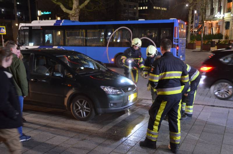 Brandweer inspecteert auto na brand