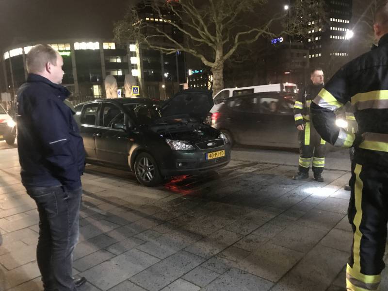 Brandweer inspecteert auto na brand