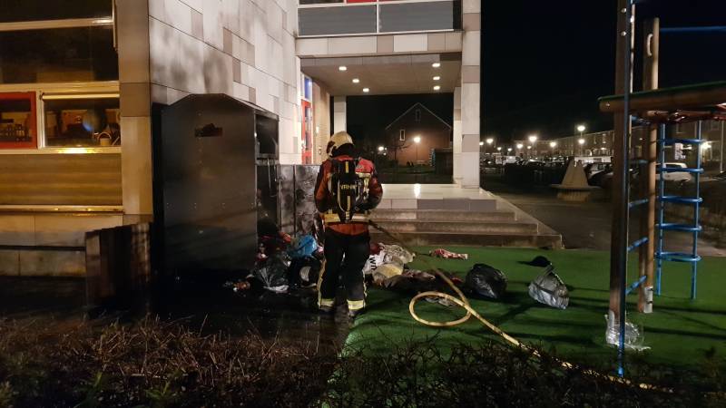 Kleding container vat vlam tegen schoolgebouw