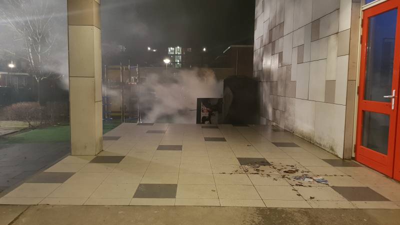 Kleding container vat vlam tegen schoolgebouw