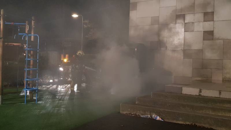 Kleding container vat vlam tegen schoolgebouw