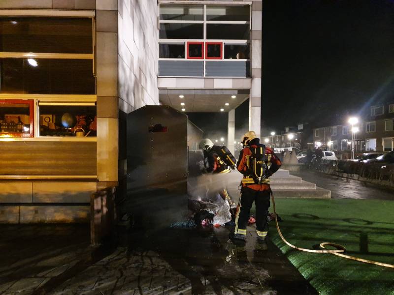 Kleding container vat vlam tegen schoolgebouw