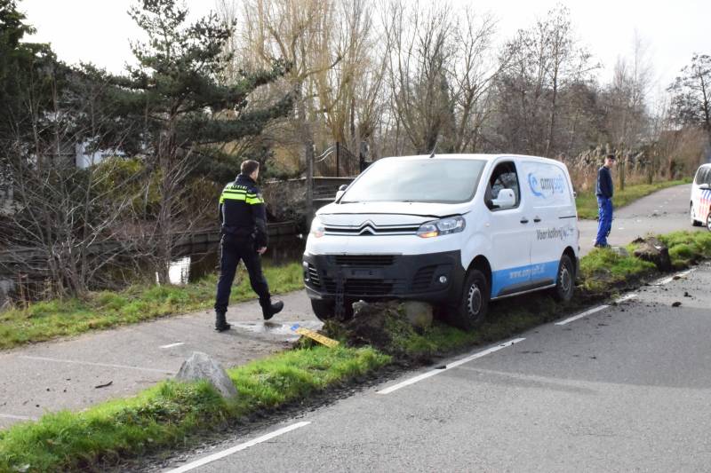 Bestelbus botst op lantaarnpaal komt tot stilstand op biggenruggen