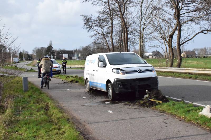 Bestelbus botst op lantaarnpaal komt tot stilstand op biggenruggen