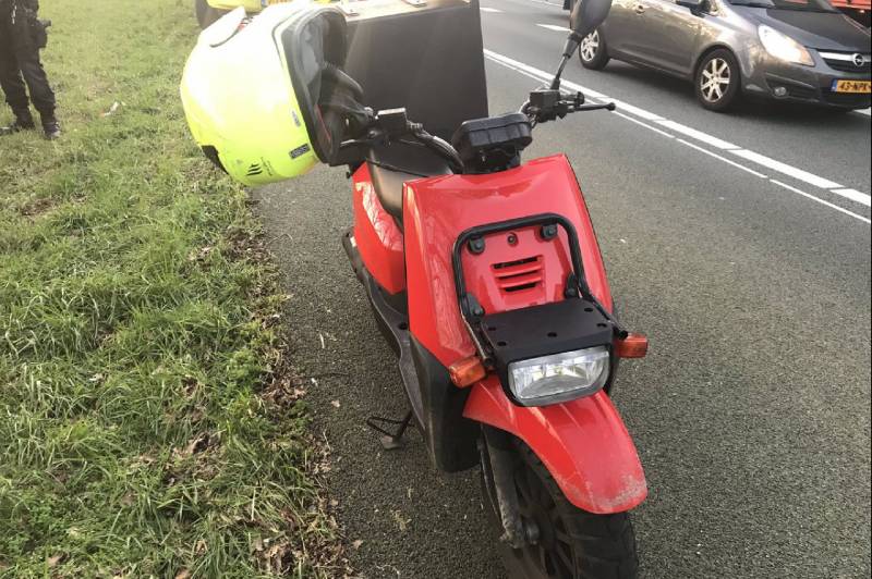 Pizzabezorger rijdt met scooter snelweg op