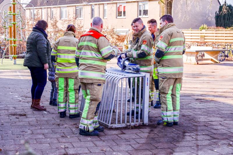 Meisje bekneld met been in doeltje op schoolplein