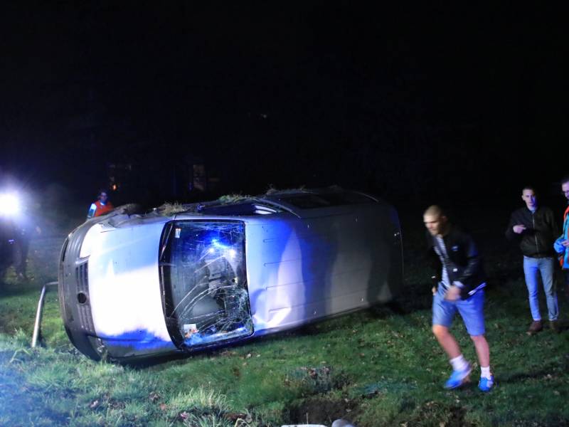 Bestelbus vliegt uit de bocht en belandt op zijkant, twee aanhoudingen