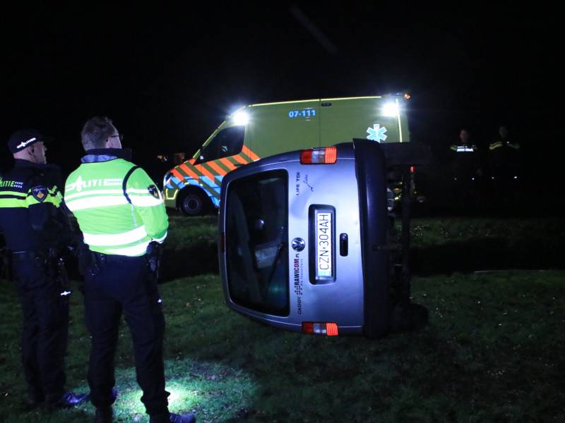 Bestelbus vliegt uit de bocht en belandt op zijkant, twee aanhoudingen