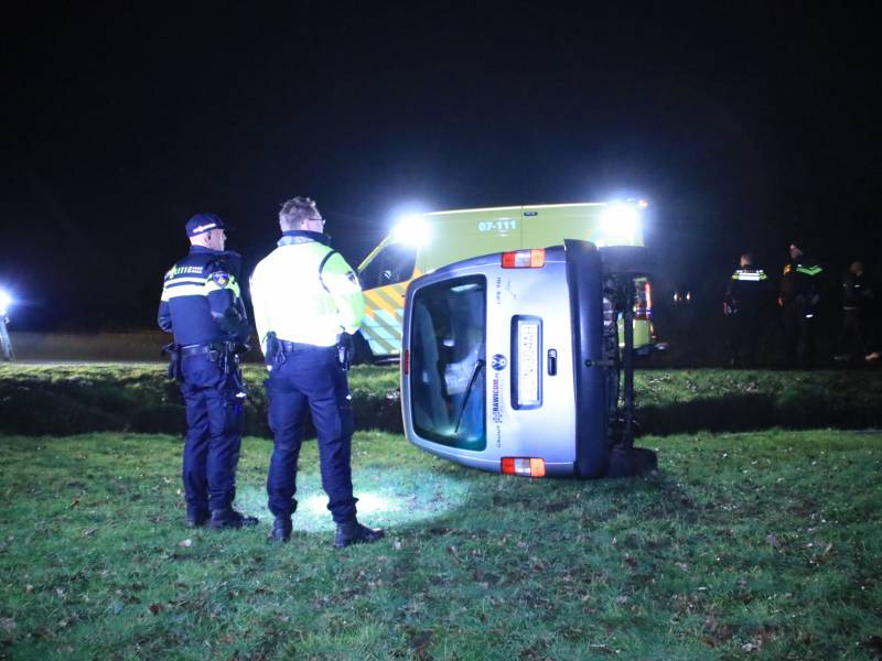Bestelbus vliegt uit de bocht en belandt op zijkant, twee aanhoudingen