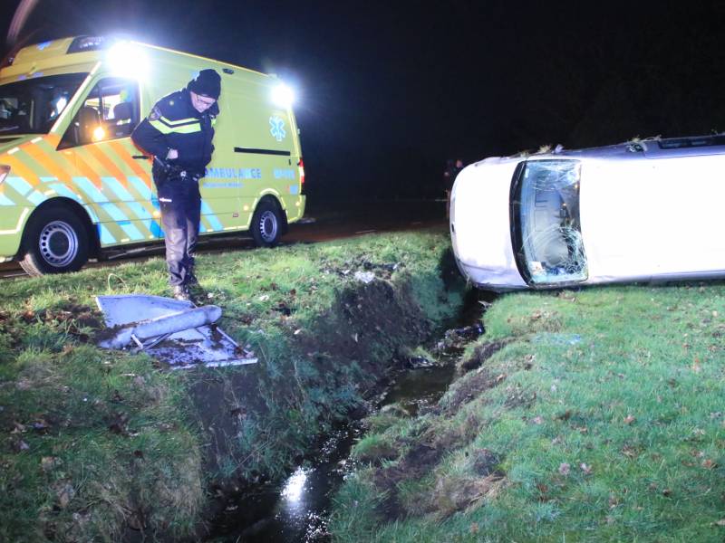 Bestelbus vliegt uit de bocht en belandt op zijkant, twee aanhoudingen